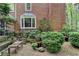 Landscaped backyard featuring beautiful plants, brick exterior home, and wooden benches at 5884 Hammersmith Rd, Stone Mountain, GA 30087
