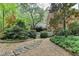 Picturesque backyard with lush landscaping, stone pathways, and home exterior at 5884 Hammersmith Rd, Stone Mountain, GA 30087