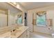 Bright bathroom with marble countertop, large mirror, and natural light from the window at 5884 Hammersmith Rd, Stone Mountain, GA 30087