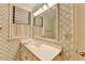 Bathroom features wallpaper, white vanity with golden fixtures, and shuttered window at 5884 Hammersmith Rd, Stone Mountain, GA 30087