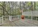 Wood deck with white railing and forested backyard at 5884 Hammersmith Rd, Stone Mountain, GA 30087