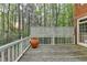 Open deck with white railing, wood planks, and greenery background at 5884 Hammersmith Rd, Stone Mountain, GA 30087