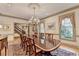 Elegant dining room with a large table, chandelier, patterned rug, and window letting in natural light at 5884 Hammersmith Rd, Stone Mountain, GA 30087