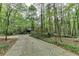 View of the property from the driveway through a wooded area at 5884 Hammersmith Rd, Stone Mountain, GA 30087