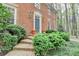 Close up view of a brick home entrance with manicured landscaping and a brick pathway, creating an appealing facade at 5884 Hammersmith Rd, Stone Mountain, GA 30087