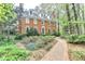Inviting brick home with a well-manicured front yard and a charming brick walkway, nestled among trees at 5884 Hammersmith Rd, Stone Mountain, GA 30087