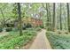 Two-story brick home with a brick walkway and a backdrop of mature trees, creating a serene atmosphere at 5884 Hammersmith Rd, Stone Mountain, GA 30087