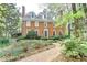 Charming two-story brick home featuring a landscaped yard and a brick walkway leading to the front door at 5884 Hammersmith Rd, Stone Mountain, GA 30087