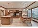 Well-lit kitchen with wooden cabinetry, kitchen island with sink, and a breakfast nook near a large bay window at 5884 Hammersmith Rd, Stone Mountain, GA 30087