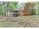 View of the rear brick exterior of a home featuring a screened porch and wooden steps at 5884 Hammersmith Rd, Stone Mountain, GA 30087
