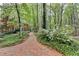 Brick pathway lined with green plants and trees leading to the home at 5884 Hammersmith Rd, Stone Mountain, GA 30087