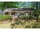 Charming single-story home featuring a brick facade, inviting front porch, and lush landscaping at 2336 Armand Ne Rd, Atlanta, GA 30324