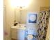 Well-lit bathroom featuring a vanity with a sink, toilet, shower with a curtain, and decorative wall art at 3716 Derringer Rdg, Loganville, GA 30052