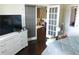 Comfortable bedroom with a gray comforter, dresser, white-trimmed doors, and a glimpse into a living area at 3716 Derringer Rdg, Loganville, GA 30052