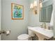 Stylish powder room with pedestal sink, golden faucet, and a framed painting at 39 Ivy Gates Ne, Atlanta, GA 30342