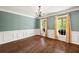 Elegant dining room with hardwood floors, wainscoting, and large windows with light-filtering curtains at 4520 Windsor Oaks Dr, Marietta, GA 30066