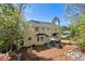 Beautiful yellow home featuring a patio, mature trees, a dark roof, and an outdoor seating area at 4520 Windsor Oaks Dr, Marietta, GA 30066