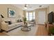 Relaxing living room offers natural light with hardwood floors, stylish furniture, and neutral color palette at 7112 Brookview Way, Riverdale, GA 30274