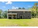 Grassy backyard featuring a covered patio, ideal for outdoor dining and entertaining with ample space at 719 Fairview Rd, Brooks, GA 30205