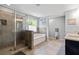 Bright bathroom featuring a glass shower, soaking tub, double vanity, and tile flooring at 719 Fairview Rd, Brooks, GA 30205