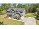 Beautiful gray two-story home featuring a charming covered porch, lush lawn and long driveway at 719 Fairview Rd, Brooks, GA 30205