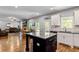 Open-concept kitchen features white cabinets, modern appliances, and a center island, perfect for entertaining at 719 Fairview Rd, Brooks, GA 30205