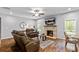 Cozy living room features a brick fireplace, comfortable seating, and plenty of natural light at 719 Fairview Rd, Brooks, GA 30205