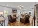 Open-concept living room features hardwood floors, a stone fireplace, and comfortable leather furniture at 719 Fairview Rd, Brooks, GA 30205