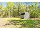 Backyard shed with double doors and windows, providing ample storage space and adding charm to the landscape at 719 Fairview Rd, Brooks, GA 30205