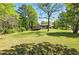 Expansive backyard featuring a ranch-style home with a sunroom under a vibrant blue sky and mature trees at 2846 Spring Lake Dr, Buford, GA 30519