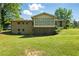 A spacious backyard shows the back of the brick home featuring a sunroom and a small staircase to the door at 2846 Spring Lake Dr, Buford, GA 30519