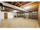 Unfinished basement with exposed ceiling, a door, and shelving for versatile storage at 2846 Spring Lake Dr, Buford, GA 30519
