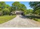 A ranch-style house with a one-car garage and long concrete driveway, surrounded by green trees and a lawn at 2846 Spring Lake Dr, Buford, GA 30519
