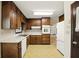 Kitchen featuring wooden cabinets, white appliances, and view into an adjacent room at 2846 Spring Lake Dr, Buford, GA 30519