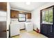 Functional laundry room with washer, dryer, window, and access door at 2846 Spring Lake Dr, Buford, GA 30519