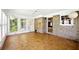 Bright sunroom featuring large windows, brick accent wall, and unique parquet wood flooring at 2846 Spring Lake Dr, Buford, GA 30519