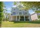 Expansive backyard with a lush lawn, mature trees, and a spacious patio beneath a multi-story home at 3890 The Battery, Duluth, GA 30096