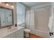 Bathroom features a shower-tub combo with a light-colored shower curtain and a decorative mirror at 3890 The Battery, Duluth, GA 30096