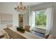Elegant dining room with wood table, tufted chairs, and chandelier lighting by a bright window overlooking green backyard at 3890 The Battery, Duluth, GA 30096