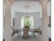 Bright dining room featuring classic columns, elegant chandelier, and large windows offering serene outdoor views at 3890 The Battery, Duluth, GA 30096