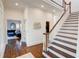 Inviting foyer with dark hardwood floors, white stairs, and views into the adjacent living room at 3890 The Battery, Duluth, GA 30096