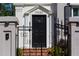 Elegant front door featuring a decorative lion knocker, classic trim, and access via a brick pathway and wrought iron gate at 3890 The Battery, Duluth, GA 30096