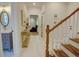 Hallway features staircase, console table with decor, and an ornate mirror in powder room at 3890 The Battery, Duluth, GA 30096