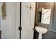 Elegant powder room features a pedestal sink, designer mirror, and sophisticated wall decor at 3890 The Battery, Duluth, GA 30096