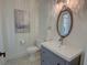 Powder room features a gray vanity with an oval mirror and decorative tile flooring at 3890 The Battery, Duluth, GA 30096