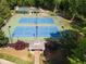 Aerial view of two well-maintained tennis courts with a gazebo and playground in a lush green community at 3890 The Battery, Duluth, GA 30096