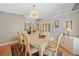 Cozy dining room featuring wood floors, cream furniture, cabinet, and warm pendant lighting at 436 Suwanee East Dr, Lawrenceville, GA 30043