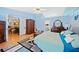 Spacious bedroom with blue walls, ceiling fan, wood floors, with adjacent bathroom and dining area access at 436 Suwanee East Dr, Lawrenceville, GA 30043