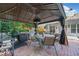 Outdoor kitchen under a gazebo complete with built-in grill, sink, and dining area at 436 Suwanee East Dr, Lawrenceville, GA 30043
