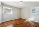 Bright bedroom featuring hardwood floors, neutral walls, and natural light from two windows at 8586 Taylor Rd, Riverdale, GA 30274
